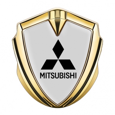 Mitsubishi Emblem Logo Schriftzug Aufkleber Goldtonfarbe Grau Hintergrund und Schwarz Logo