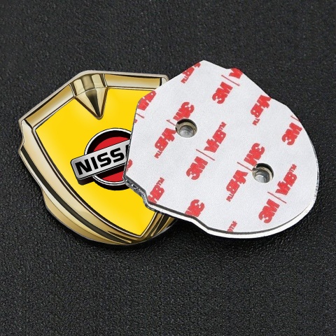 Nissan Badge Self Adhesive Gold Yellow Background Front Grey Logo