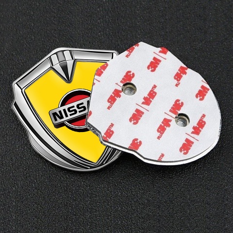 Nissan Badge Self Adhesive Silver Yellow Background Front Grey Logo