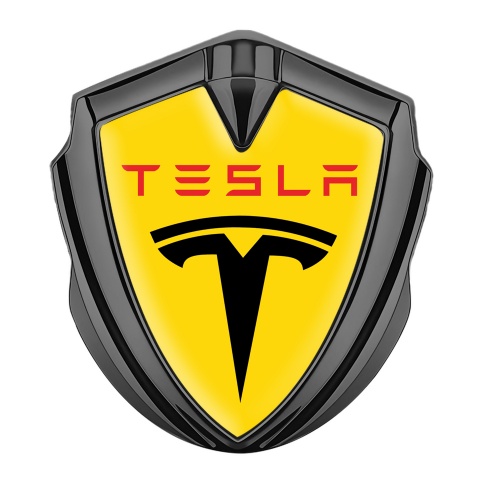 Tesla Emblem Abzeichen selbstklebend Graphit Tonfarbe Gelb Hintergrund mit Schwarz Rote Logo