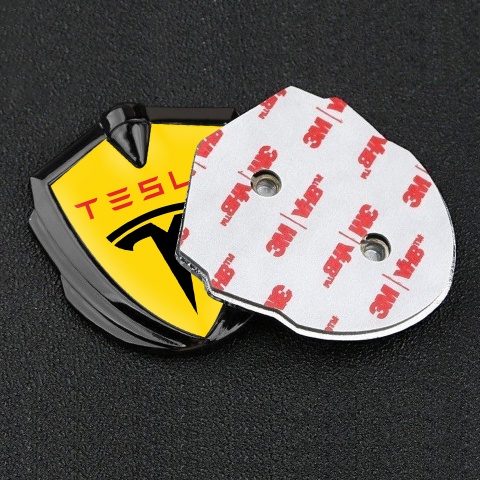 Tesla Emblem Abzeichen selbstklebend Graphit Tonfarbe Gelb Hintergrund mit Schwarz Rote Logo