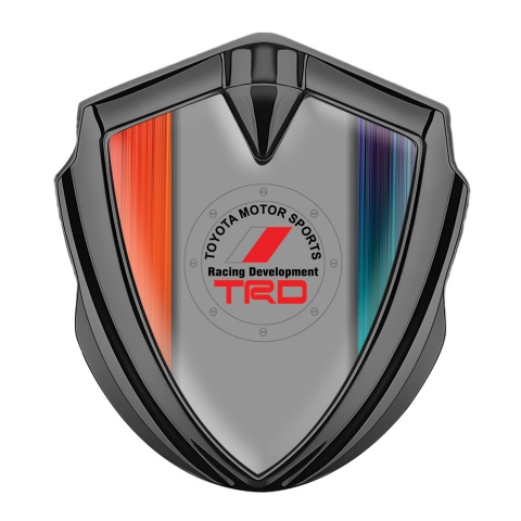 Toyota Emblem Abzeichen Graphit Tonfarbe mit Orangeblaue Kratzer Hintergrund und TRD Logo
