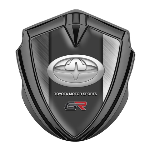 Toyota GR Emblem Abzeichen Graphit Tonfarbe mit Gebursteter Stahl Hintergrund und Modernes Logo