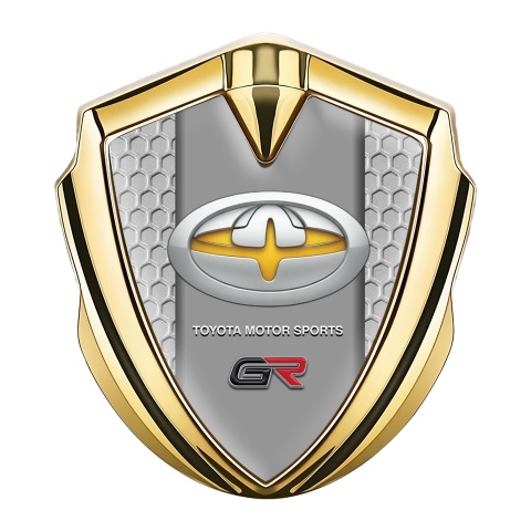 Toyota GR Abzeichen selbstklebend Goldtonfarbe mit Wabeneffekt Hintergrund und Gelb Motiv Logo
