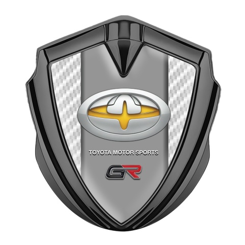 Toyota GR Emblem Abzeichen selbstklebend Graphit Tonfarbe mit Weiss Kohlenstoff und Gelb Motiv Logo