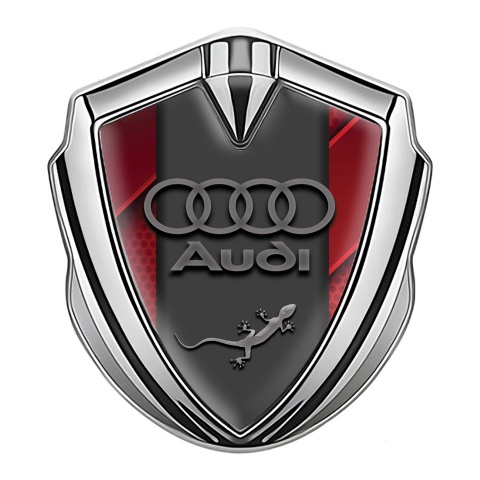 Audi Quattro Emblem Abzeichen Silbertonfarbe mit Rote Fragmente Hintergrund und Grau logo
