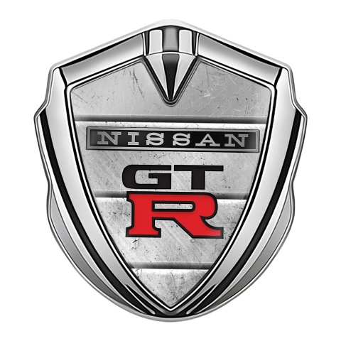 Nissan GTR Emblem Auto Zeichen Silbertonfarbe Steinplatten Hintergrund mit Schwarz Rote Logo