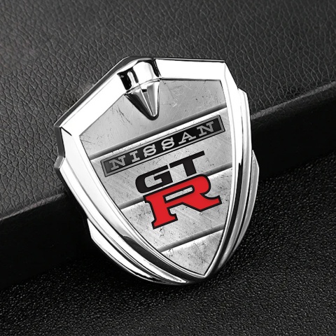 Nissan GTR Emblem Auto Zeichen Silbertonfarbe Steinplatten Hintergrund mit Schwarz Rote Logo
