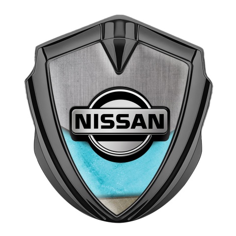 Nissan Emblem Abzeichen selbstklebend  Graphit Tonfarbe Turkis Motiv Basis mit Grau Logo