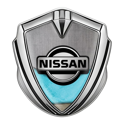 Nissan Emblem Abzeichen selbstklebend Silbertonfarbe Turkis Motiv Basis mit Grau Logo