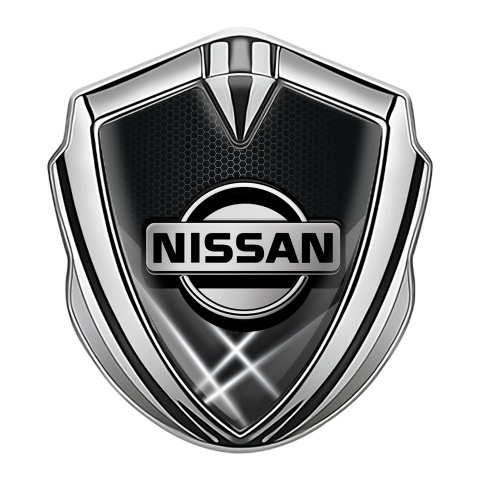 Nissan Emblem Logo Schriftzug Aufkleber Silbertonfarbe Dunkles Fundament mit Weiss Lichter Effekt