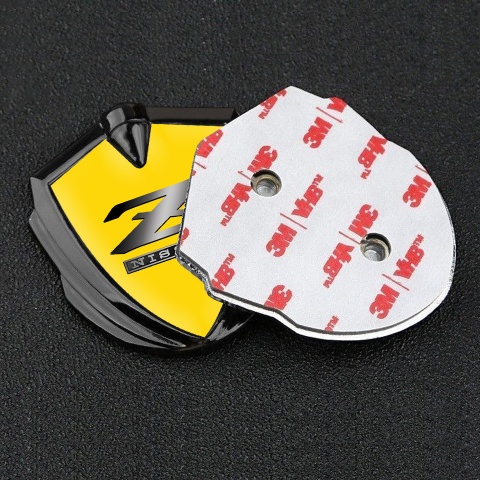 Nissan Z Emblem Abzeichen Graphit Tonfarbe Gelb Hintergrund mit Metall Logo Design