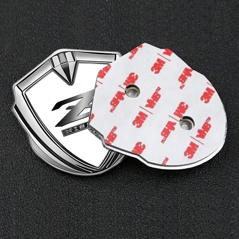 Nissan Z Emblem Abzeichen selbstklebend Silbertonfarbe Weiss Fundament mit Metall Logo Auflage