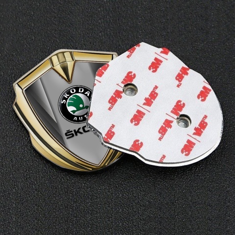 Skoda Emblem Abzeichen selbstklebend Goldtonfarbe mit Grau Fragmente und Grau Logo Panel