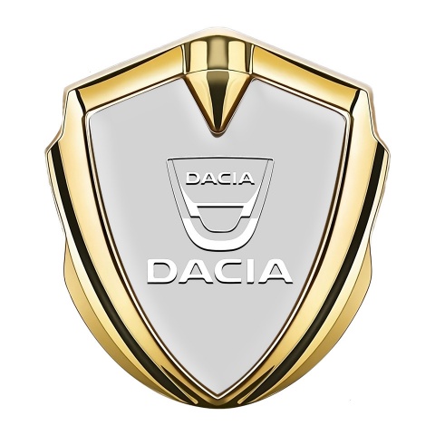 Dacia Abzeichen selbstklebend Goldtonfarbe Grau Basis mit Weiss Logo