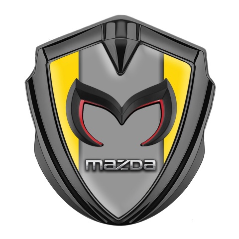 Mazda Emblem Abzeichen selbstklebend Graphit Tonfarbe mit Gelb Hintergrund und Grau Logo Panel