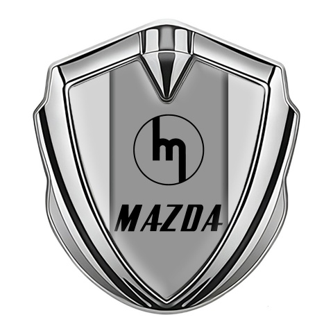 Mazda Emblem Abzeichen Silbertonfarbe mit Grau Hintergrund und Retro Logo Design
