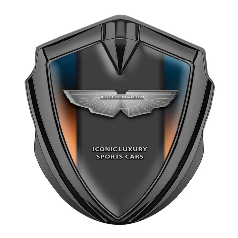 Aston Martin Emblem Abzeichen Graphit Tonfarbe mit Orange Blau Hintergrund und Grau logo