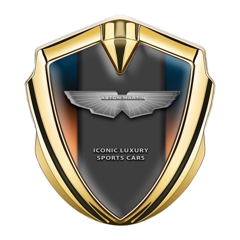 Aston Martin Emblem Abzeichen Goldtonfarbe mit Orange Blau Hintergrund und Grau logo