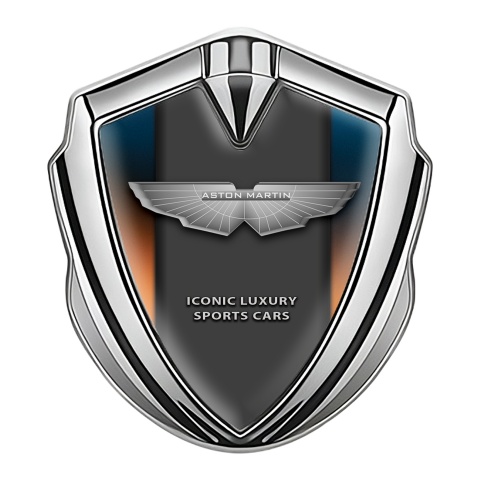 Aston Martin Emblem Abzeichen Silbertonfarbe mit Orange Blau Hintergrund und Grau logo