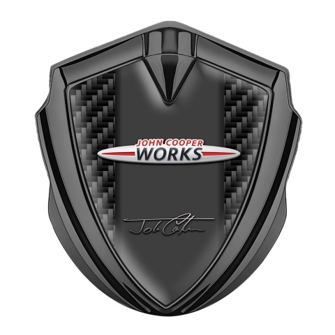 Mini Cooper Abzeichen selbstklebend Graphit Tonfarbe mit Kohlenstoff Hintergrund John Cooper Works Logo