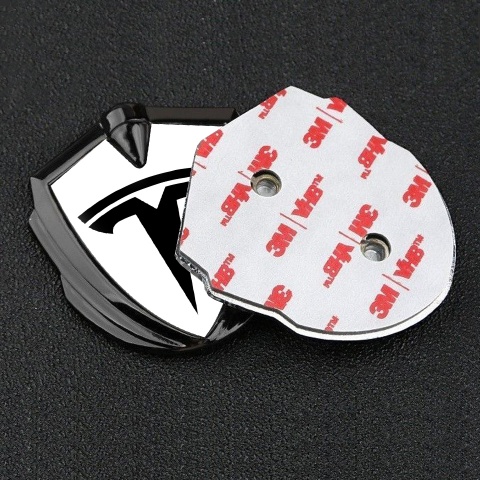Tesla Emblem Abzeichen Graphit Tonfarbe Weiss Hintergrund mit Grosses Logo Stil