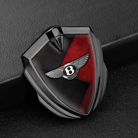 Bentley Selbstklebendes Metallaufkleber Emblem Graphit Tonfarbe mit Schwarz Rote Textur Hintergrund