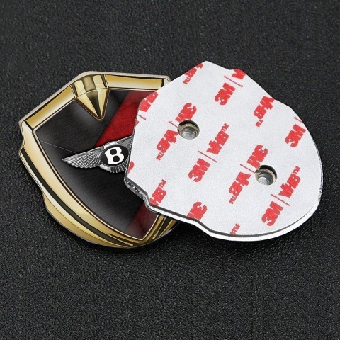 Bentley Selbstklebendes Metallaufkleber Emblem Goldtonfarbe mit Schwarz Rote Textur Hintergrund